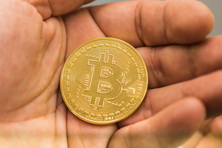 Hand holding golden Bitcoin virtual money.の写真素材