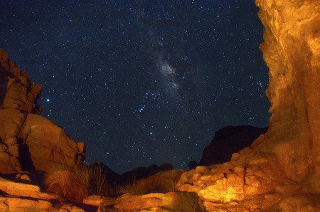 Surrounded by the red sea mountains using the camp fire along with a low shutter technique, to capture this photo. Enjoying the night sky with the fire mountains.の写真素材