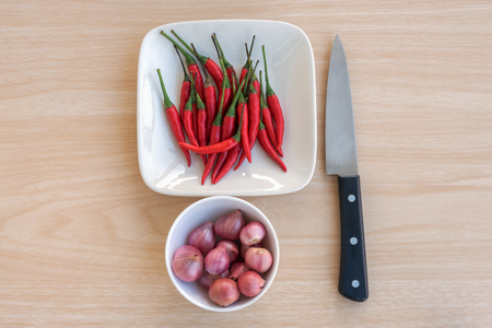 The red chillies and onions with knife are on the tableの写真素材