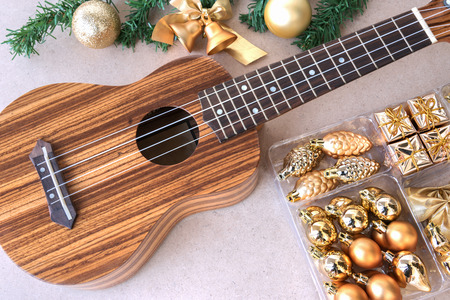 The ukulele on the wooden table with christmas golden decoration set, ukulele is a gift from the christmas dayの写真素材