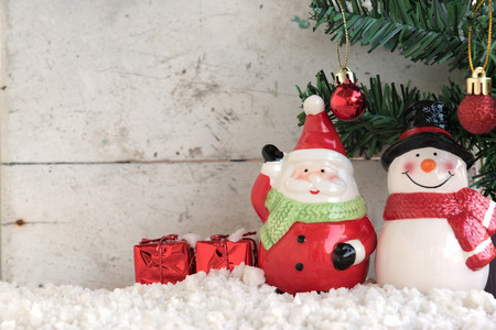 santa claus and snowman on the snow with christmas tree already decorated in vintage backgroundの写真素材