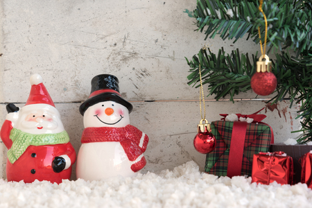 santa claus and snowman on the snow with christmas tree already decorated in vintage backgroundの写真素材