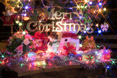 snowman and a  decorated christmas tree with light, santa claus is coming in townの写真素材