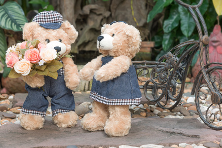 two teddy bears with roses on garden background, love concept for valentines day, wedding and anniversaryの写真素材