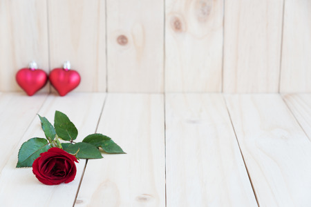red rose and two hearts on wooden background with space, love concept for valentines day, wedding and anniversaryの写真素材
