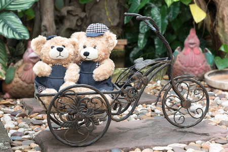 two teddy bears with a bicycle on garden background, concept loveの写真素材