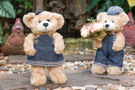 two teddy bears with roses on garden background, concept loveの写真素材