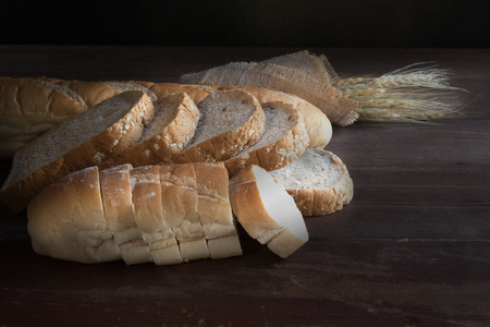 still life with bread and wheat on wooden table