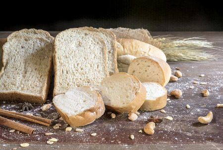 still life with bread and wheat on wooden table, close upの写真素材