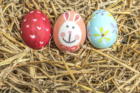 Close up of colorful easter eggs on hay backgroundの写真素材