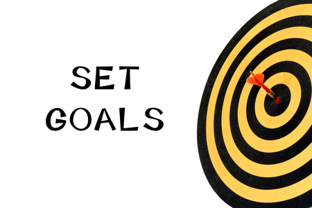 Words set goals and dart target with arrow on bullseye, Goal target success business investment financial strategy concept, abstract backgroundの写真素材