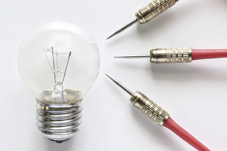 Closeup bulb lamp with three dart on white background, idea and business success conceptの写真素材