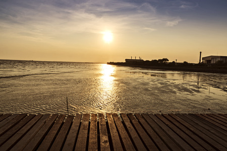wooden bridge with beautiful sunset background above the sea, warm toneの写真素材