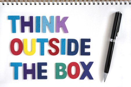 Colorful wood letters word think outside the box in open notebook with a pen, Quotes business conceptの写真素材