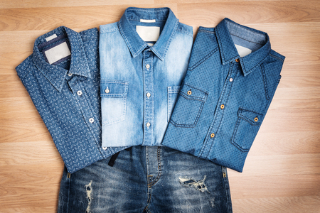 Men casual fashion outfit on wooden table top view, blue cotton shirts and jeans pants still life with vintage styleの写真素材
