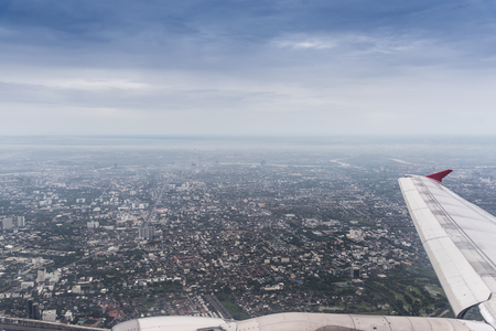 bangkok thailand cityscape aerial view from window on airplane with wing in the blue sky with clouds, landscapeの写真素材