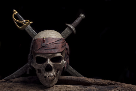 pirate skull with two swords over darkness background still life styleの写真素材