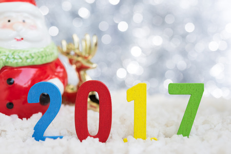 2017 Happy new year on snow with Santa claus and gold reindeer over abstract blurred festive bokeh light glitter background with copy spaceの写真素材