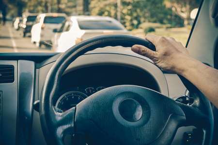 Man driving car using one hand on the road, vintage toneの写真素材
