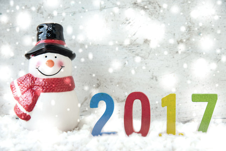 Snowman and snowfall with wooden 2017 with copy space for season greetingの写真素材