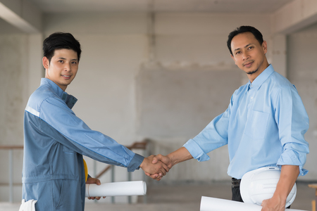 Confidence businessman shaking hands to seal a deal with engineer in building, Business success conceptの写真素材
