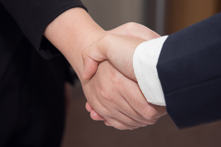 Two confident Businessman and businesswoman shaking hands over a deal signing a contractの写真素材