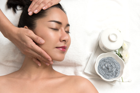 Close up of beautiful young asian woman lying with closed eyes and preparation face or head massage in spa or wellness, Beauty healthy lifestyle and relaxation conceptの写真素材