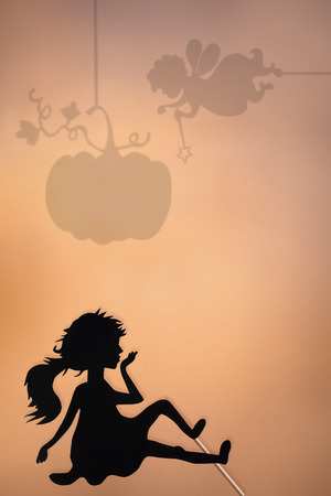 Cinderella shadow puppet and shades of Fairy Godmother and Pumpkin on the screen of shadow theater, copy space background.の写真素材