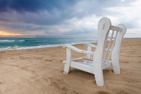 Empty armchair on the deserted beach before the storm, copy space background.の写真素材