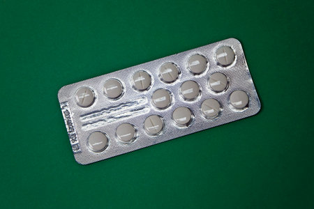 Rio de Janeiro, Brazil - October 31, 2020: Blister pack of pills on green background.のeditorial素材