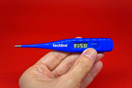Rio de Janeiro, Brazil - January 23, 2021: Hand holding a digital thermometer for body temperatureのeditorial素材