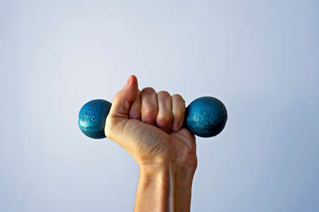 Green dumbbell on hand in a bright backgroundの写真素材