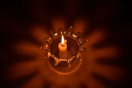 Candle in candlestick, shadows and lightsの写真素材