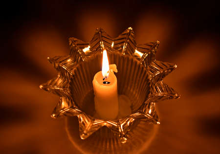 Candle in candlestick, shadows and lightsの写真素材