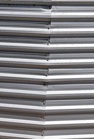 Gray corrugated metal plate surrounding wastelandの写真素材