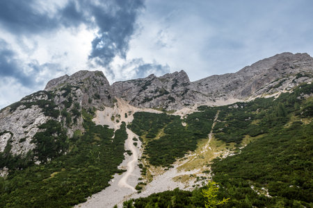 Explore the stunning landscape of Vrsic Pass in Bovec, Slovenia showcasing majestic mountains and a dramatic sky. Perfect for nature lovers.の写真素材