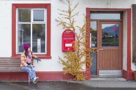 Women tourist looking the red old mailbox in Iceland.の写真素材