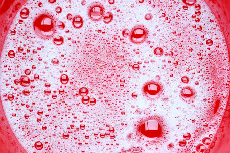 Soap bubbles in red basinの写真素材