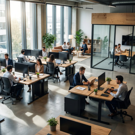 Sunlight streams into a modern, open-concept office, illuminating diverse professionals working diligently at their desks and in meetings.の素材