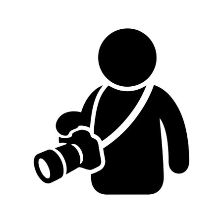 Photographer holding a digital camera with a strap presented as a minimalist black silhouette icon...