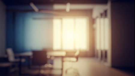 Sunlight streams through large windows illuminating a modern office with minimal furniture and a cozy atmosphereの素材