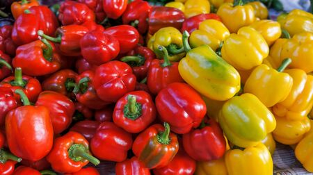 A pile of bell peppers or sweet peppers of red color on display for sale.の写真素材
