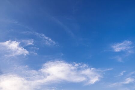 Blue sky background with tiny clouds. white fluffy clouds in the blue skyの写真素材