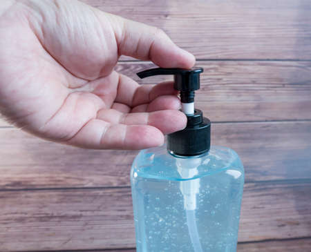 hands using wash hand sanitizer gel pump dispenser. Clear sanitizer in pump bottle, for killing germs, bacteria and virus.の写真素材