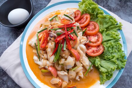 Stir-fried squid with salted egg yolk, onion, spring onion and Chili pepper on white plate. Food concept. Thailand seafood cuisine. thai foodの写真素材
