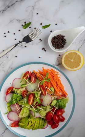 healthy vegan bowl. Avocado, tomato, Red Radish,carrot, Sunflower seedling,Black pepper, lemon,  and vegetables salad. Top view. vegan food, clean eating, dietingの写真素材