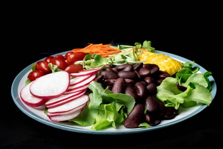 bowl of salad with vegetables ,fresh green oak salad, tomatoes, corn, Red beans, Carrot , red...
