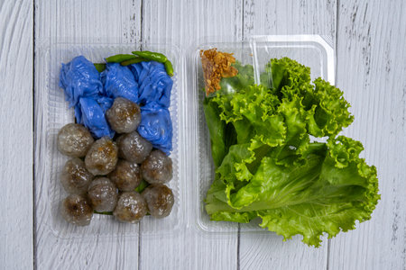 Colorful Vietnamese snacks displayed in containers on a white wooden tableの写真素材
