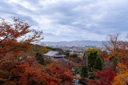 NOV 28 2025 Kiyomizu-dera, Japan :Autumn view of Kyoto from a hilltop temple with colorful leaves and distant mountains under a cloudy skyのeditorial素材