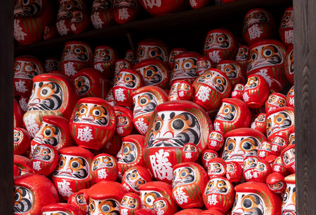 Shelves are filled with numerous daruma dolls, each uniquely painted and symbolizing perseverance and good luck. This vibrant display showcases Japanese culture and artistry.の写真素材
